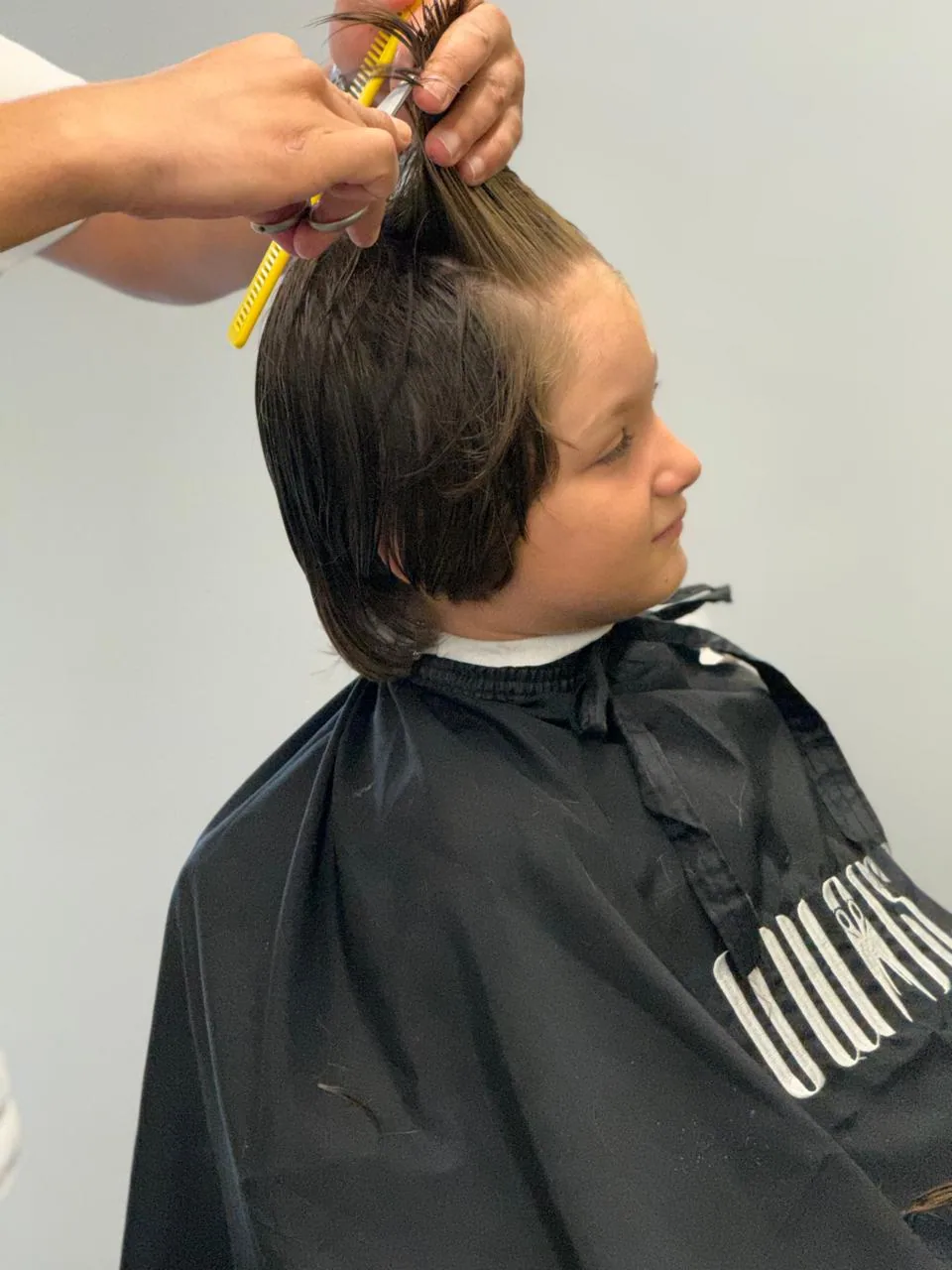 A child's haircut at Owais Barbershop in Tla’ Al-Ali