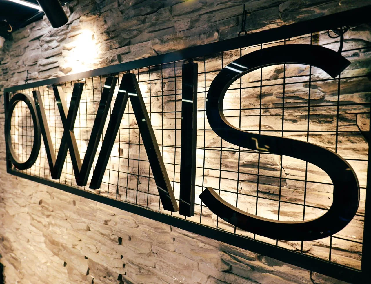 شعار OWAIS على الجدار الحجري